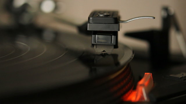 Close up HD movie of a record player playing a vinyl black record. 