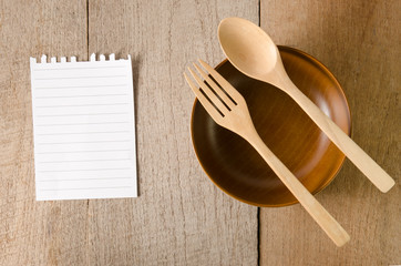 Blank note paper with wooden spoon on tabletop