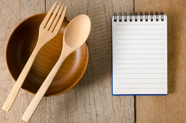 Blank note book with wooden spoon on tabletop