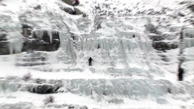 Ice climber zoom in steep mountain waterfall HD