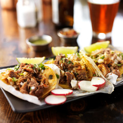 three authentic mexican street tacos with barbacoa, carnitas and chicken