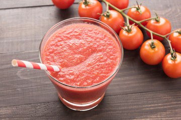 Healthy vegetable. Glass of red tomato juice on wooden table