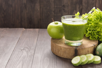 Healthy green vegetables and green fruit smoothie on rustic wood