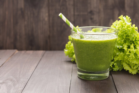 Healthy green vegetables and green fruit smoothie on rustic wood