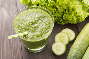 Healthy green vegetables and green fruit smoothie on rustic wood