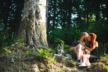 beautiful couple sitting in a forest near the tree