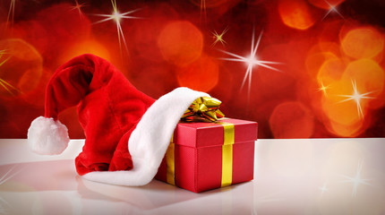 Santa Claus hat with gift red background front view