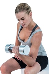Fototapeta na wymiar Muscular woman working out with dumbbells 