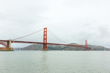 Golden Gate bridge view from the shore in the cloudy day.