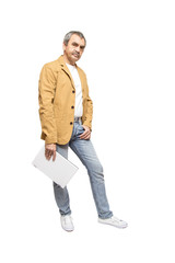 Мужчина стоит на белом фоне с ноутбуком в руках.