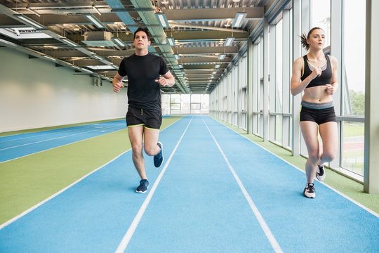 Couple Running On The Indoor Track