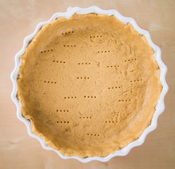 Wholemeal whole wheat pie crust in ceramic oven dish - 93973107