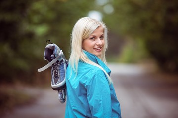 Happy blonde holding inline skates
