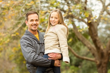 Happy father and his daughter posing in park