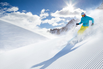 Skier skiing downhill in high mountains