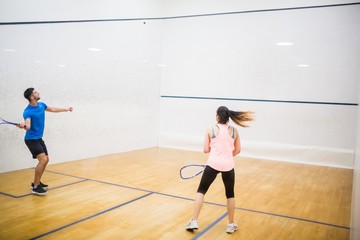 Fototapeta na wymiar Competitive couple playing squash together