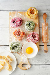 raw colorful pasta and rolling pin