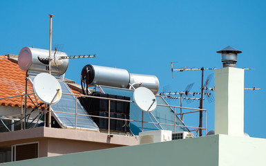 Solar water heating system and satellite television dishes on the rooftops.