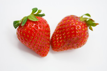Two strawberries close up on white background
