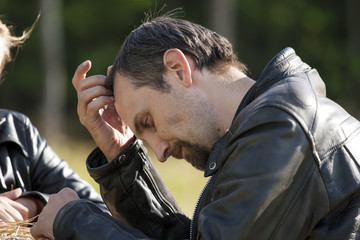 Portrait of severe man in black leather jacket sunny day
