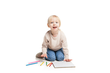 Little cute girl sitting on floor and drawing with colourful