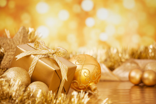 Christmas scene with gold baubles and gift, gold background