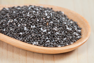 chia seeds in a wooden scoop on wood cup