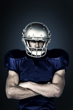 Composite image of american football player with arms crossed