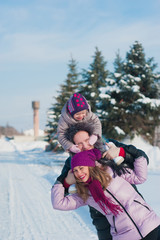 Fototapeta na wymiar Young beautiful family in bright clothes winter fun jumping and running, snow, lifestyle, winter holidays