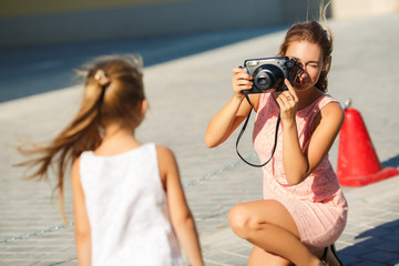 Mom photographs her daughter on the street in the city