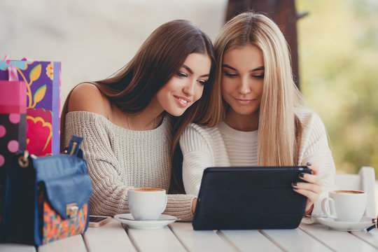 Girlfriends consider photos on the digital tablet