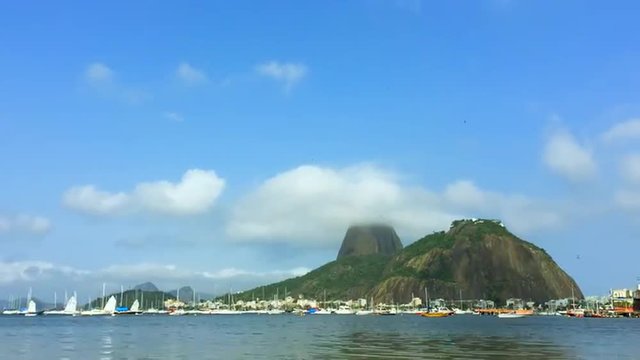Mist and clouds swirl around a view of Sugarloaf Mountain from Botafogo Bay in Rio de Janeiro, Brazil