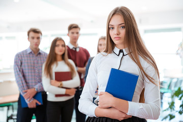 Female student standing with classmates on background