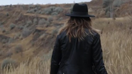 Девушка в шляпе гуляет по гористой местности