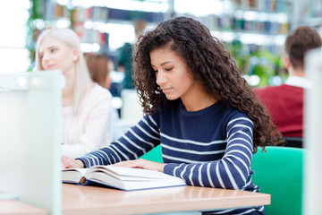 Afro american woman reading book in classroom
