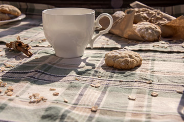 Cup and oat biscuits on the tablecloth