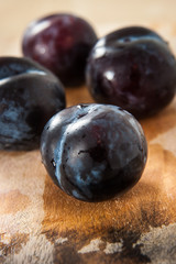 Red plums with water drops on cutting board