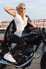 Fototapeta na wymiar Biker girl sitting on vintage custom motorcycle