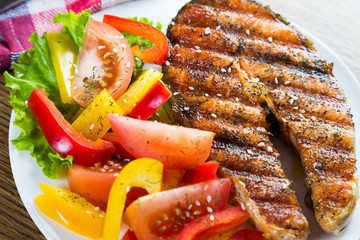 Grilled salmon steak with fresh vegetables
