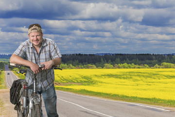 Obraz premium Road in blooming field yellow flowers summer landscape at