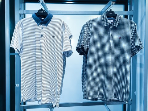 New polo shirts on hangers in a shop location