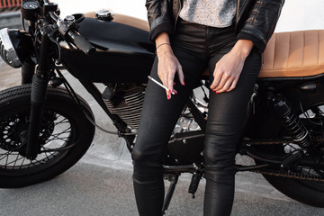 Young woman on motorcycle smoking sigarette