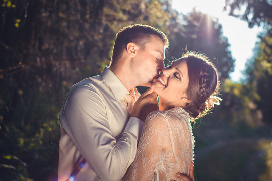 Happy wedding couple, hugging and smiling together under romantic light.