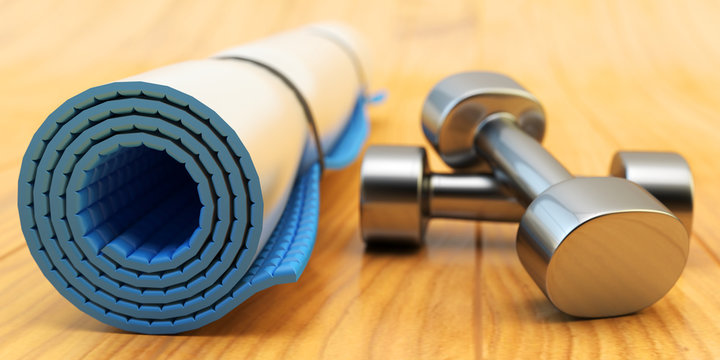 Fitness workout and slimming exercises concept, weight loss gym equipment: blue yoga mat and black metallic dumbbells on wooden floor of training class