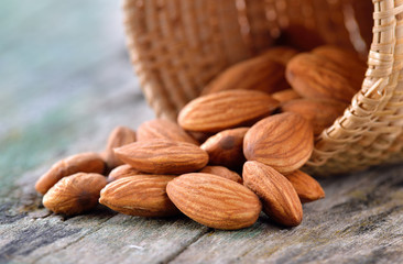 almonds in the basket on old wood background