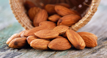 almonds in the basket on old wood background
