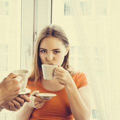 young couple drinking tea or coffee at home