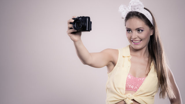 Pin up girl woman taking photo with camera.