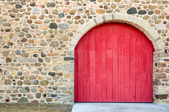 Bright Red Arched Door in a Stone Wall
