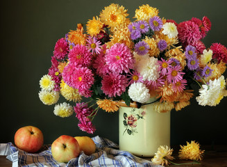 Still life with a bouquet of chrysanthemums and apples.